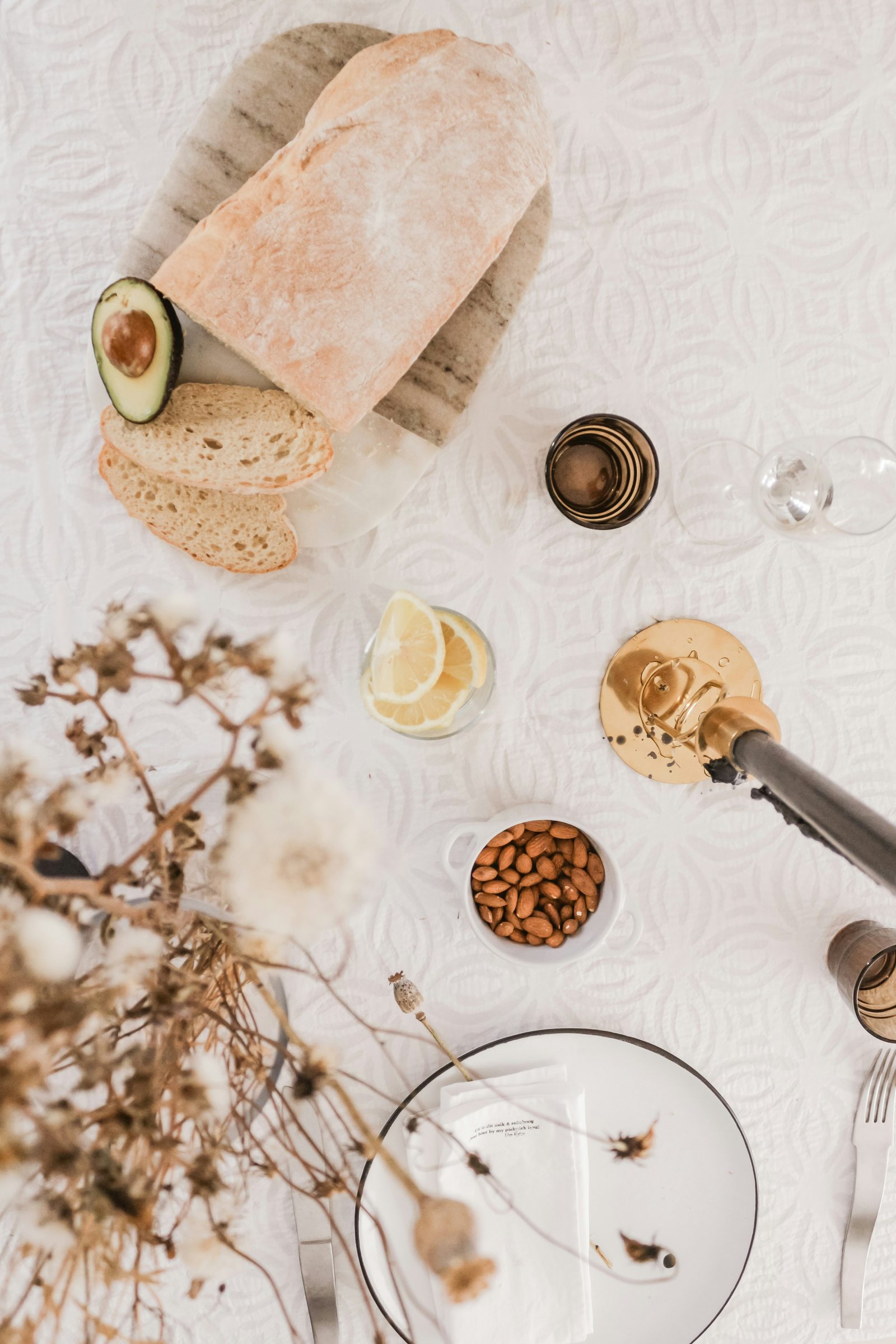 Bread, citrus, and table settings arranged for a meal